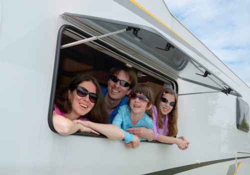 happy-parents-traveling-with-kids-having-fun-motorhome happy-parents-traveling-with-kids-having-fun-motorhome